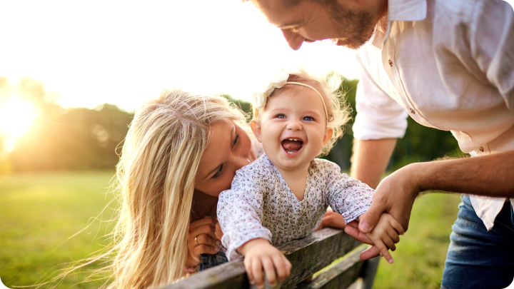 young parents with newborn baby in a field