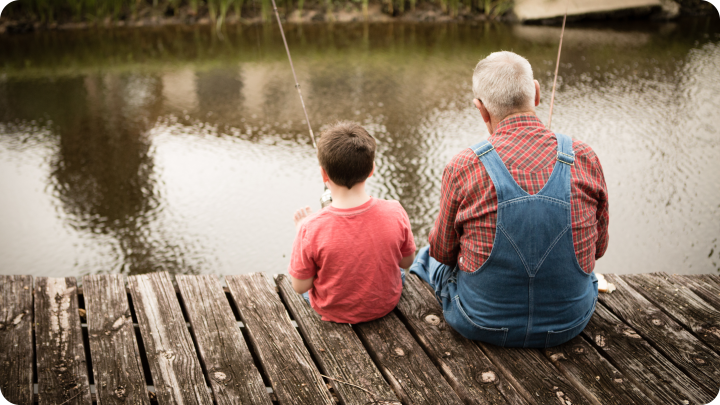 grandfather and grandson fishing on a pier