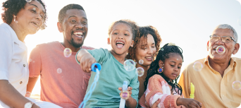 family of grandparents and children blowing bubbles