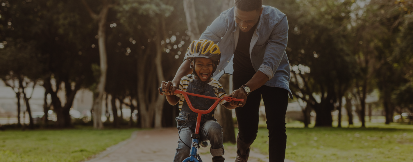father and son in neighborhood riding bike